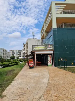 a building with a red truck parked in front of it at Pool View Studio, Pollo Resort, Sunny Beach in Sunny Beach