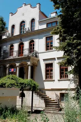 a large white building with stairs in front of it at Citadel Guest House in Varna City