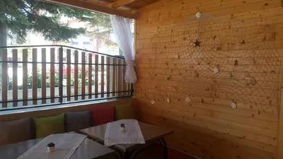 a restaurant with two tables and a balcony at Sineva Guest House in Ravda