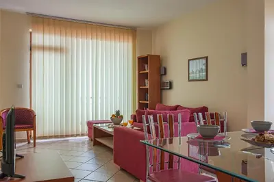 a living room with a red couch and a table at Garden of Eden PMG Apartments in Sveti Vlas
