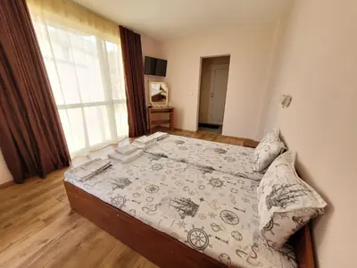 a large bed in a bedroom with a large window at Guesthouse Iceberg in Ravda