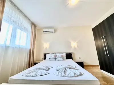 a bedroom with a bed with white towels on it at Menada Sky Dreams Apartments in Sveti Vlas