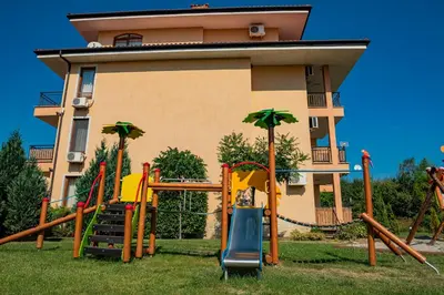 a playground in front of a house at Menada Sky Dreams Apartments in Sveti Vlas