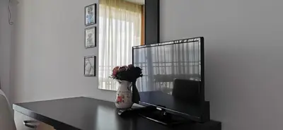 a desk with a vase of flowers and a mirror at Вила Лазурен бряг in Chernomorets