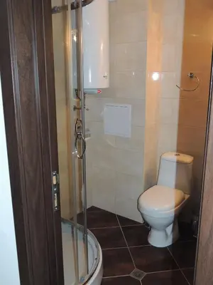a bathroom with a toilet and a glass shower at Вила Лазурен бряг in Chernomorets