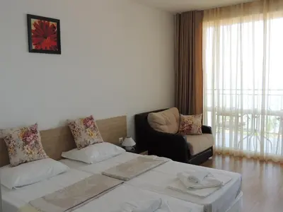 a hotel room with two beds and a couch at Вила Лазурен бряг in Chernomorets