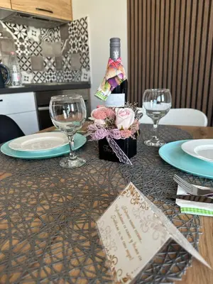a table with two plates and wine glasses on it at Joy Apartment Burgas center free parking in Burgas City