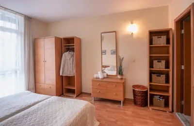 a bedroom with a bed and a dresser and a mirror at Elit 4 Apartments in Sunny Beach
