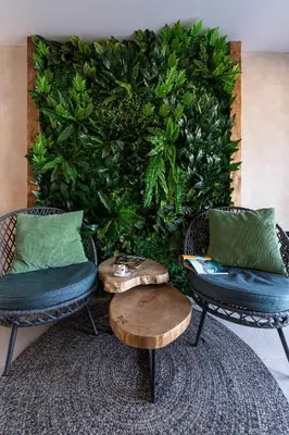 a green wall with two chairs and a table at Utopia Forest in Burgas City