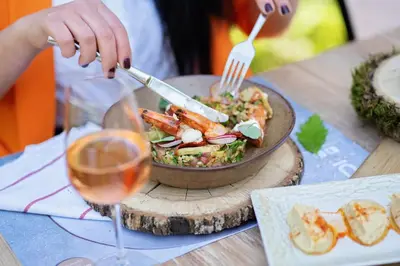 a person is preparing a dish of food on a table at Utopia Forest in Burgas City