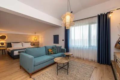 a living room with a blue couch and a bed at Utopia Forest in Burgas City