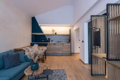 a living room with a blue couch and a table at Utopia Forest in Burgas City
