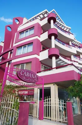 a pink building with a sign in front of it at Cabana Beach Club Complex in Nesebar