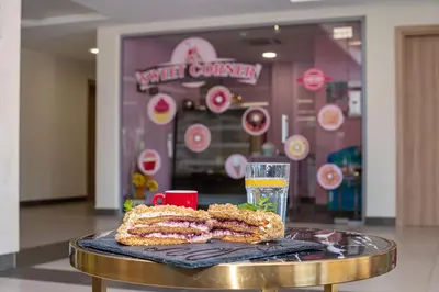 a table with a sandwich and a glass of juice at Belvedere Hotel - All inclusive in Primorsko
