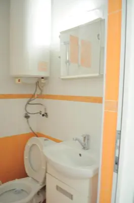 a bathroom with a toilet and a sink and a mirror at Ivanka Guest House in Obzor