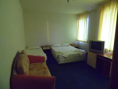 a hotel room with two beds and a television at Hotel Amigos in Obzor