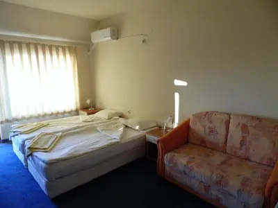 a hotel room with a bed and a couch at Hotel Amigos in Obzor