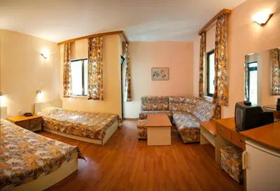a living room with a couch and a tv at Hotel Sigma in Kiten
