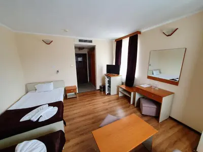 a bedroom with a bed and a desk and a mirror at Hotel Sigma in Kiten