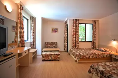 a hotel room with two beds and a desk at Hotel Sigma in Kiten
