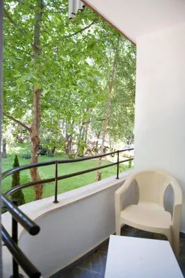 a balcony with a table and chairs and a large window at Hotel Sigma in Kiten