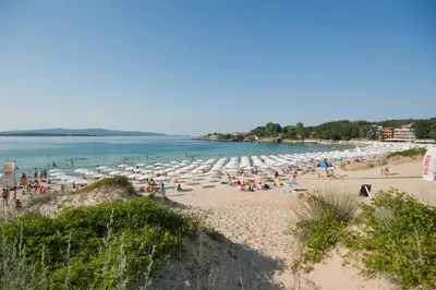 a beach with many umbrellas and people on it at Hotel Sigma in Kiten