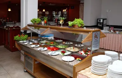 a buffet with plates and food on a table at Hotel Yunona - All Inclusive in Sunny Beach