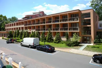 a large building with cars parked in front of it at Hotel Yunona - All Inclusive in Sunny Beach