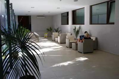 a woman sitting in a waiting room with a laptop at Hotel Yunona - All Inclusive in Sunny Beach