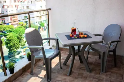 a table and chairs on a balcony with fruit on it at Central Plaza in Pomorie