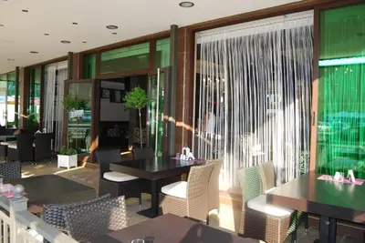 a restaurant with tables and chairs and a window at Central Plaza in Pomorie