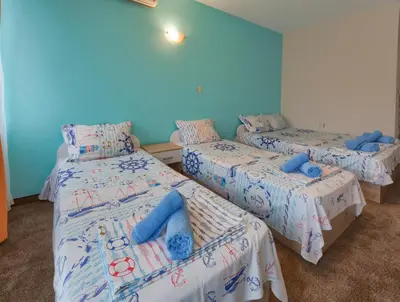 three beds in a room with blue walls at Kazlarov Guest House in Kiten