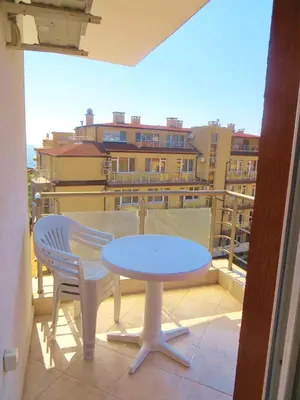 a table and chairs on a balcony with a view of a city at Apartments in Azalia 2 Complex in Nesebar