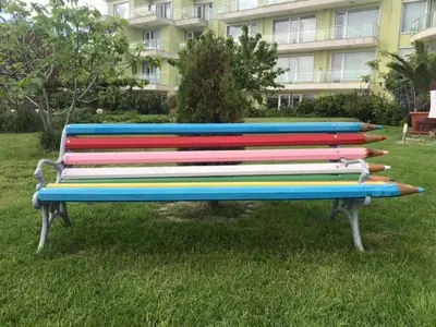 a colorful bench in the grass in front of a building at Villa St Anna in Sozopol