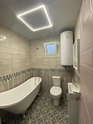 a bathroom with a tub and a toilet and a sink at Бунгала Виктория - Камчия in Kamchia
