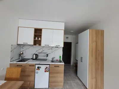 a kitchen with white cabinets and a white refrigerator at Lily Beach Resort in Sozopol