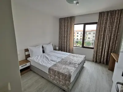 a bedroom with a bed and a large window at Lily Beach Resort in Sozopol
