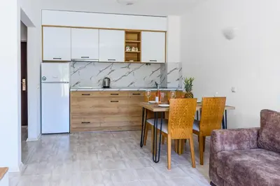 a kitchen with a table and chairs and a refrigerator at Lily Beach Resort in Sozopol