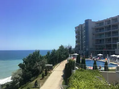 a walkway next to a building next to the ocean at Плажни Апартаменти Силвър Бийч - Silver Beach Sea Apartments in Byala