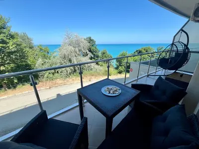 a balcony with a table and chairs and the ocean at Плажни Апартаменти Силвър Бийч - Silver Beach Sea Apartments in Byala