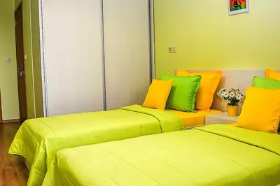 two beds in a room with yellow and green at Sunny in Burgas City