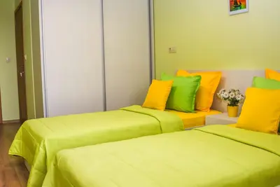 two beds in a room with yellow and green at Sunny in Burgas City