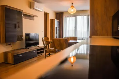 a living room with a television and a room with a table at Sunny in Burgas City