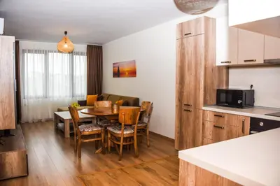 a kitchen and a dining room with a table and chairs at Sunny in Burgas City