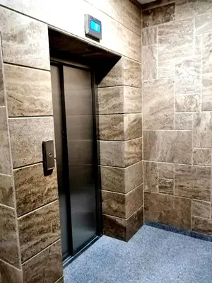 a elevator door in a bathroom with stone walls at Sunny in Burgas City
