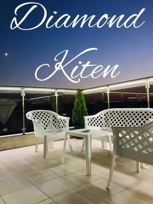 two chairs and a table on a balcony with a sign at Diamond Kiten in Kiten