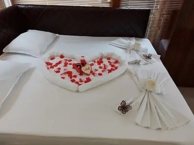 a white bed with a heart and flowers on it at Diamond Kiten in Kiten
