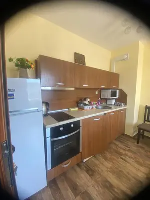a kitchen with wooden cabinets and a white refrigerator at AMADEUS 5 in Sunny Beach