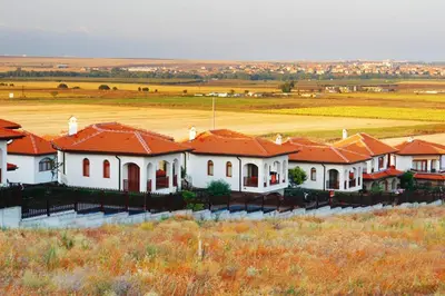 a row of houses with red roofs in a field at Generaator House in Aheloy