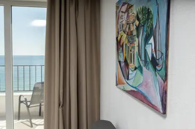 a painting hanging on a wall next to a window at JI HOTEL in Sozopol